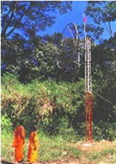 Two young Buddhist monks standing beside the Kothmale radio-link antenna